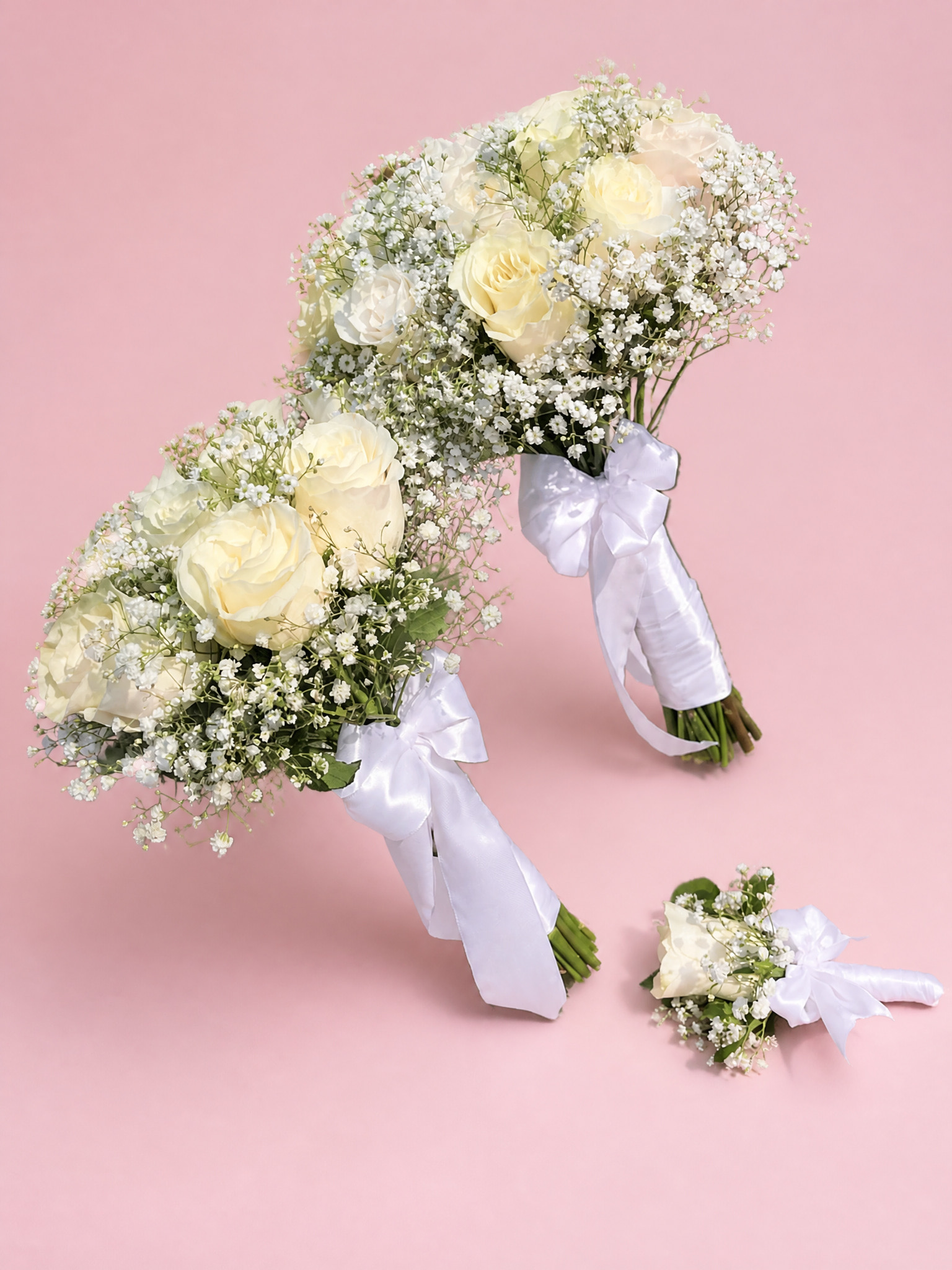 Two white rose bridal bouquets and a boutonniere